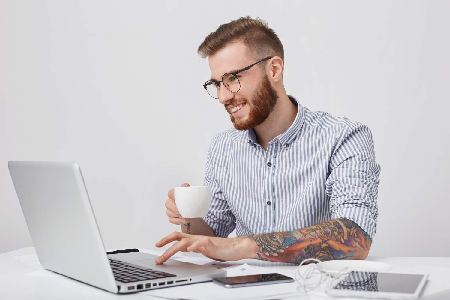 a man drinking coffee and using a laptop